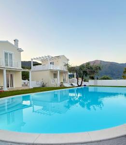 a large swimming pool in front of a house at Corfu Olive Village with Swimming Pool Castello Di Vista in Análipsis