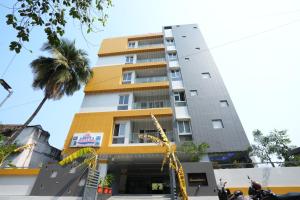 a tall building with a palm tree in front of it at ADITYA BEACH SUITES in Visakhapatnam