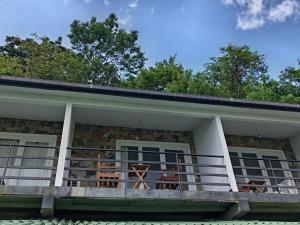 a house with a balcony with chairs on it at Glenview hotel & homestay in Kandy