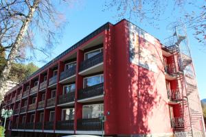 an apartment building with a red facade at Hotel Atlas Sport in Garmisch-Partenkirchen