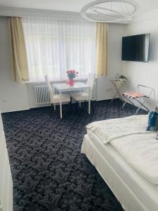 a hotel room with a bed and a table and chairs at Haus Anna-Marie in Feldberg