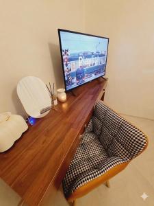 a television sitting on top of a wooden desk with a chair at 전주한옥마을 스테이네슬 in Jeonju