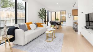 a living room with a white couch and a table at Fleetwood Atelier in Frankston South