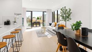 a kitchen and living room with a table and chairs at Fleetwood Atelier in Frankston South