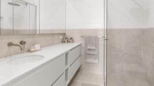 a white bathroom with a sink and a shower at Fleetwood Atelier in Frankston South +11 photos