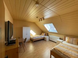 a room with a bed and a desk and a tv at Gästehaus Juhl - Ruhige Zimmer, Studios und Apartments in Rangendingen