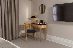 a desk with a lamp and a chair in a room at Newton Park Country House Hotel in Burton upon Trent