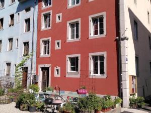 a red building with a table in front of it at Maison La Coquille in La Chaux-de-Fonds