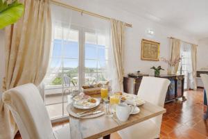 a dining room with a table and chairs and a window at Encanto dos Montes in Alvor