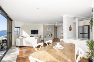 a living room with a table and a couch at Tranquil Escape - Koala Hotspot - 2 Bed 2 Bath Apt Spectacular Sea Views in Soldiers Point
