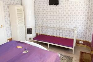 a bedroom with a bed with a purple blanket at Vaihmalan Hovi in Lempäälä