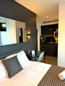 a bedroom with a large bed and a kitchen at Spice Serviced Apartments in Sydney