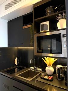 a kitchen with a sink and a microwave at Spice Serviced Apartments in Sydney