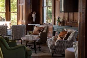 a room with chairs and a table and windows at Newton Park Country House Hotel in Burton upon Trent