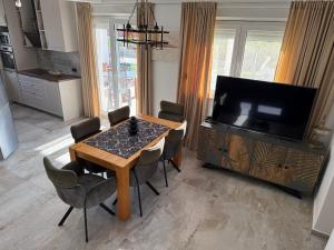 a living room with a dining room table and a television at Villa Daly in Primošten