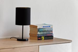 a stack of books sitting on a table with a lamp at Appartement Panoramablick in Lustenau