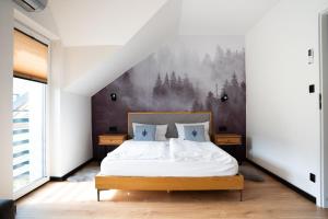 a bedroom with a bed and a painting on the wall at Nad Lipami - apartament z tarasem blisko stoku Sczyrk in Szczyrk