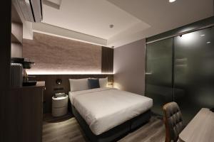 a bedroom with a bed and a table in a room at Fun Stay Inn Hanzhong in Taipei