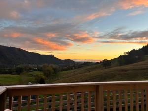 a view of the sunset from the deck of a house at Rural Getaway in Thames