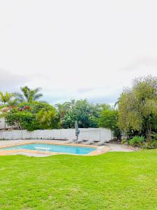 a swimming pool in a yard with a grass field at The Nathaniel in Blue Bend