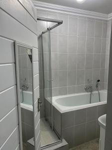 a bathroom with a shower and a tub and a sink at Pule's Home & Studio Apartments in Maseru +106 photos