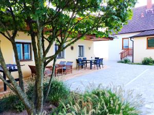a patio with tables and chairs in a house at Ferienzimmer Reinisch in Tattendorf in Tattendorf