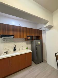 a kitchen with a sink and a refrigerator at RF Condotel in Mactan Island