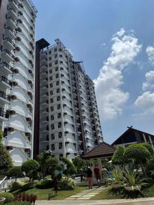 a tall apartment building with people walking in front of it at RF Condotel in Mactan Island