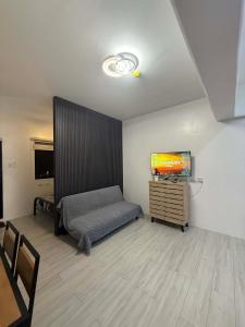 a bedroom with a bed and a tv on a wall at RF Condotel in Mactan Island
