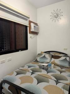 a bed sitting in a room with a window at RF Condotel in Mactan Island