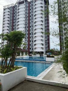 a large apartment building with a large swimming pool at RF Condotel in Mactan Island +4 photos
