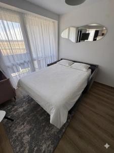 a bedroom with a white bed and a large window at Breeze Studio in Palanga