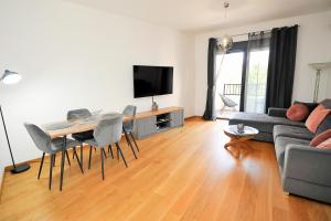 a living room with a couch and a table with chairs at SeaWolf Apartment in Bečići