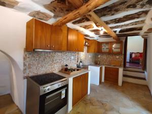 a kitchen with wooden cabinets and a stove at Ktima Kariofillis in Révmata