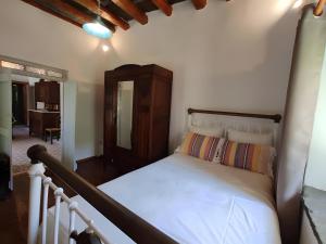 a bedroom with a white bed with a wooden headboard at Ktima Kariofillis in Révmata