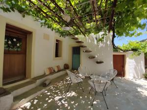 a patio with a table and chairs under a tree at Ktima Kariofillis in Révmata