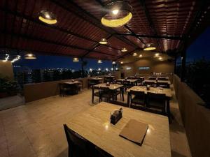 a restaurant with tables and chairs on a rooftop at Hotel Liora in Rajkot