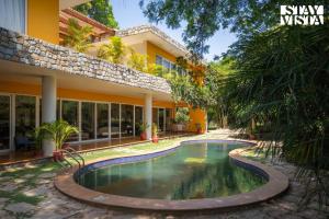 a swimming pool in front of a building at StayVista at The Hideout Farms with Lawn and private Pool in Kurukshetra