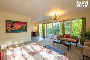 a living room with a bed and a couch at StayVista at The Hideout Farms with Lawn and private Pool in Kurukshetra +24 photos