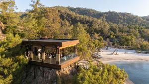 a house on the side of a mountain overlooking a body of water at Ahama - Relais & Châteaux in Fethiye