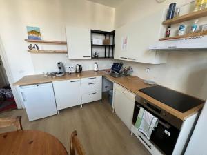 a kitchen with white cabinets and a wooden counter top at Duplex sympa Verviers in Verviers