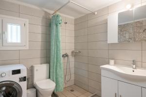 a bathroom with a toilet and a sink and a washing machine at Angelina's Cute House in Neapoli Voion +40 photos