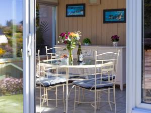 a glass table and chairs on a patio at Gîte Pors Mabo in Trébeurden +17 photos