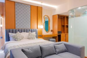 a bedroom with a large bed and a couch at THE SAND Suites & Villas in Ngurah Rai International Airport +45 photos
