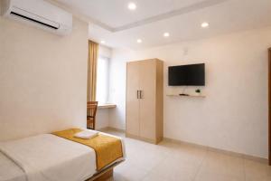 a bedroom with a bed and a flat screen tv at Tara inn in Alwaye