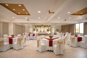 a banquet hall with tables and chairs in a room at Tara inn in Alwaye