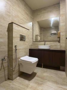a bathroom with a toilet and a sink and a mirror at Hotel Liora in Rajkot +16 photos