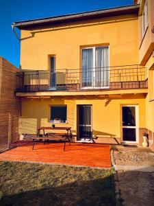 a house with a picnic table and a balcony at Jarmočná Apartmán in Stará Ľubovňa