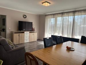 a living room with a table and a television at Schöne Wohnung Mit Dem Garten in Jübek