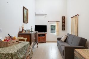 a living room with a couch and a tv at Angelina's Cute House in Neapoli Voion